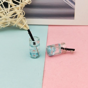 Κοντινό πλάνο DIY μίνι μπουκάλια ρητίνης με μπλε λουλούδια και μεταλλικά άγκιστρα