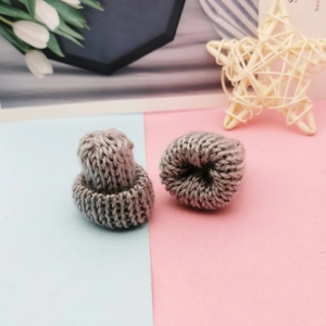 Detail of two mini grey knitted hats for DIY crafts with a thick wool texture