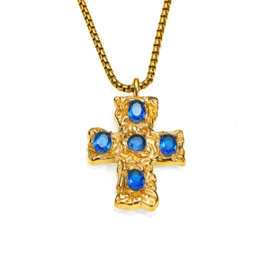 Détail du pendentif croix avec texture or martelé et cinq pierres précieuses bleues