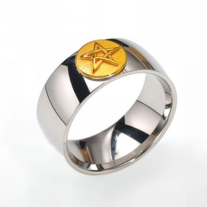 Detail of wide stainless steel ring with two-tone finish and gold star emblem