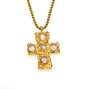 Gros plan détaillé du pendentif croix martelé avec oxydes de zirconium dorés