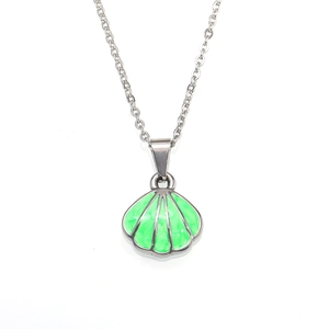 Detailed close-up of shell pendant necklace with green enamel inlay and silver chain