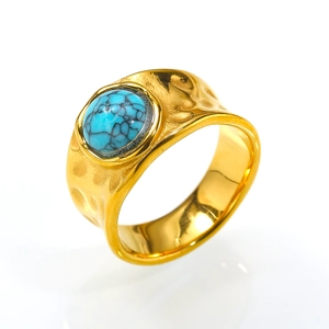 Close-up of hammered gold band ring featuring a round turquoise stone with natural textures