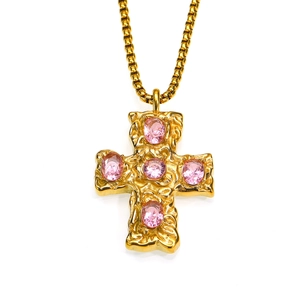 Détail du pendentif croix dorée avec texture martelée et zircons roses ovales