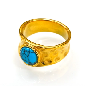 Detail of vintage golden hammered ring featuring a round turquoise natural stone inlay