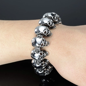 Detail of a punk rock stainless steel skull link bracelet worn on a male wrist