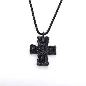 Vue détaillée du pendentif croix gothique noire avec relief texturé et cinq pierres noires