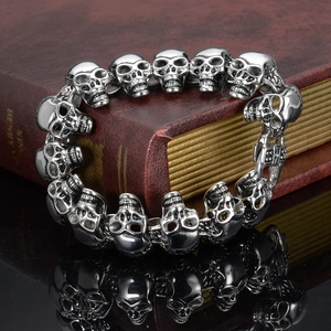 Gothic skull link bracelet in polished stainless steel displayed on a vintage book