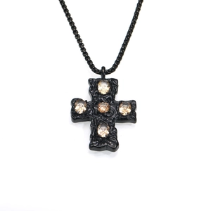 Détail macro du pendentif croix noire martelée de style gothique avec pierres en zircon