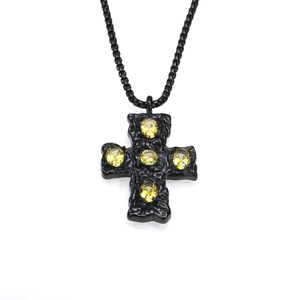Vue macro du pendentif croix gothique noire avec texture martelée et pierres de zircon jaune