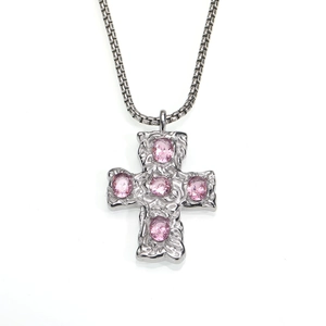 Détail du pendentif croix argentée avec zircons roses et texture martelée précise