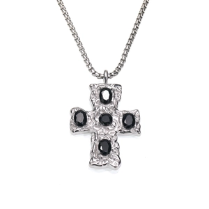 Détail du pendentif croix avec texture martelée et cinq pierres précieuses noires ovales