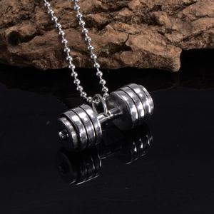Detailed view of silver fitness dumbbell pendant with beaded chain on black surface