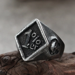 Vintage 1%er Herrenring im Biker-Stil mit Totenkopf und antikem Gold-Finish auf Holz