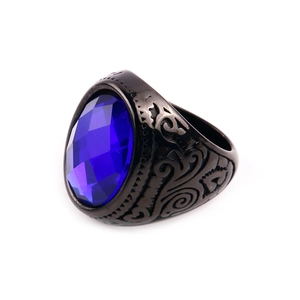 Macro shot of an oval blue gemstone set in a vintage engraved black steel ring
