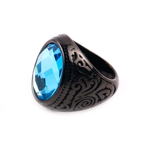 Macro detail of men's titanium steel ring with blue oval gemstone and ethnic engraving