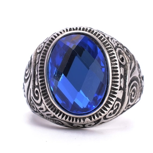 Detailed view of oval blue gemstone and vintage engraved patterns on titanium steel ring