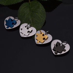 Detail of puzzle heart pendants in blue, silver, rose gold and black stainless steel