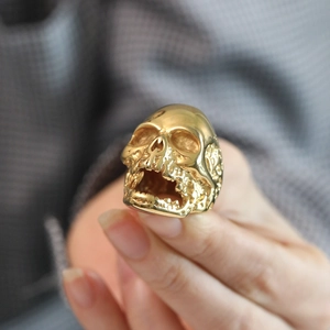 Macro detail of gothic skull ring in gold finish featuring intricate punk carving