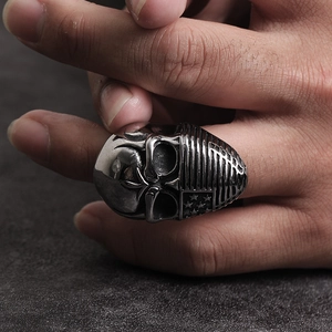 Detailed view of punk skull ring with US flag pattern held by hand showing biker style