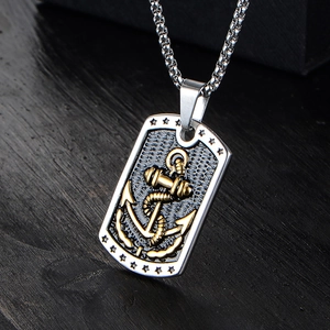 Close-up of rectangular anchor dog tag pendant with golden relief on textured metal