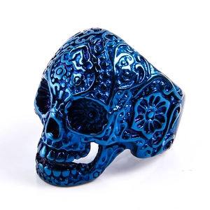 Dettaglio dell'anello teschio punk in metallo blu con rilievi e motivi ornamentali
