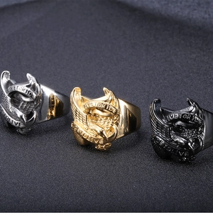 Macro detail of men's eagle biker rings in silver, gold, and black with engraved slogans