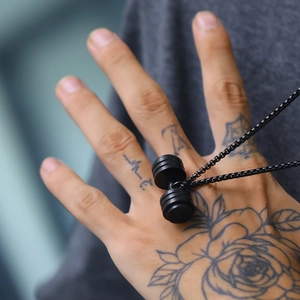 Close-up of matte black dumbbell pendant with a box chain for fitness enthusiasts