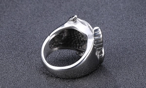 Close-up detail of a vintage men's stainless steel ring featuring a bold bull head totem