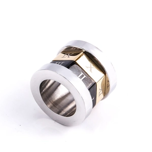 Détail macro d'une bague en acier tricolore avec gravures de chiffres romains sur l'anneau