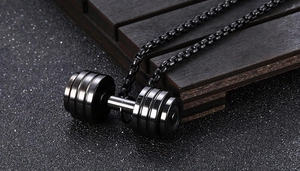 Macro detail of a black dumbbell pendant in stainless steel with a beaded link chain