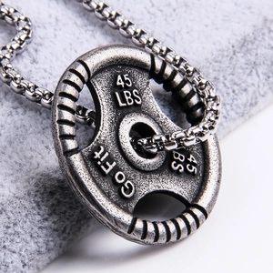 Macro detail of antique silver 45 LBS weight plate pendant for gym fitness jewelry