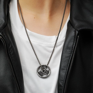 Close-up of retro silver weight plate pendant with Go Fit engraving and box chain