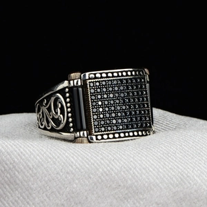 Detailed macro of vintage silver ring with pavé black stones and ornate filigree sidewalls
