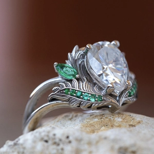 Elegante zilveren kroonring met een peervormige hoofdsteen en smaragdgroene accenten