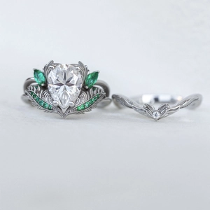 Macro detail van kroonring met peervormig kristal en groene accenten in bladstructuur