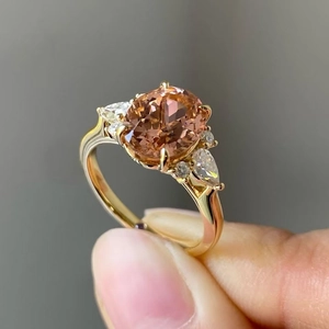 Detailopname van een ovale champagne zirkoon ring met een koper-gouden zetting