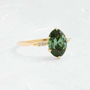 Détail macro d'une bague émeraude verte ovale avec placage en or 18 carats