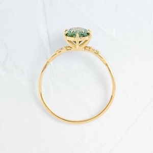 Détail macro d'une bague émeraude verte ronde plaquée or 18 carats avec serti à griffes