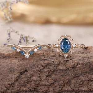 Set di anelli retrò in oro rosa con gemma blu ovale e fascia a V con cristalli su legno