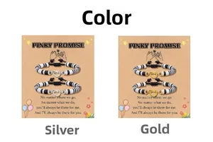 Detail van kralenarmbanden met hart op Pinky Promise-kaart in zilver en goud