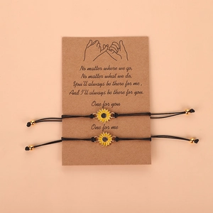 Detail of sunflower charm bracelets with black braided cords on gift message card