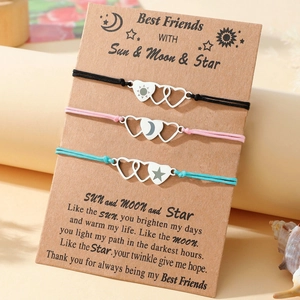 Detail of three woven friendship bracelets with sun moon star charms on kraft card