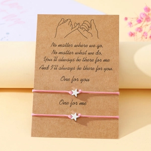 Pink cord friendship bracelets with star charms presented on a sentimental gift card