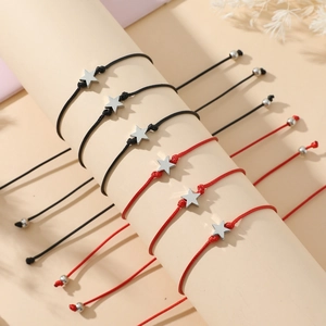 Detail of star charm braided bracelets set in black and red on a display stand