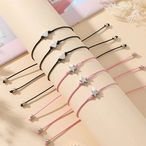 Detail of 6-piece woven star and heart charm bracelets set on a cylindrical stand