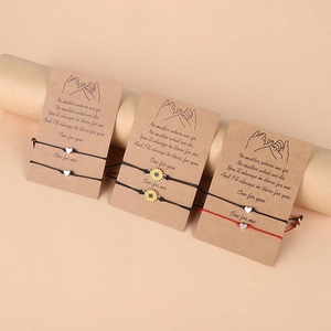 Détail de bracelets d'amitié tissés avec cœur et tournesol sur cartes cadeaux