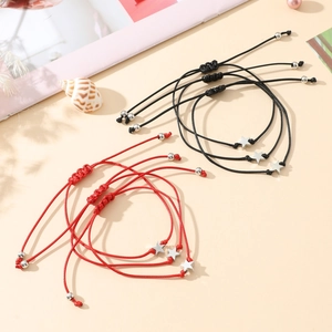 Detail of red and black braided star charm bracelets with adjustable cord knots
