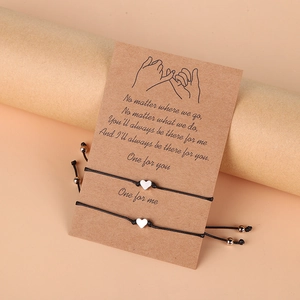 Détail de bracelets en corde tressée avec cœur pour couples sur carte cadeau