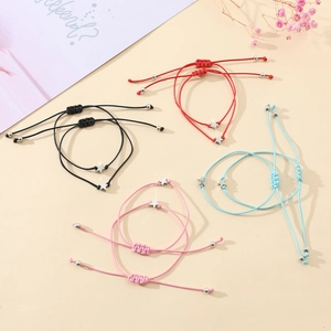 Detail of four colorful star charm braided bracelets with adjustable slip knots on cards